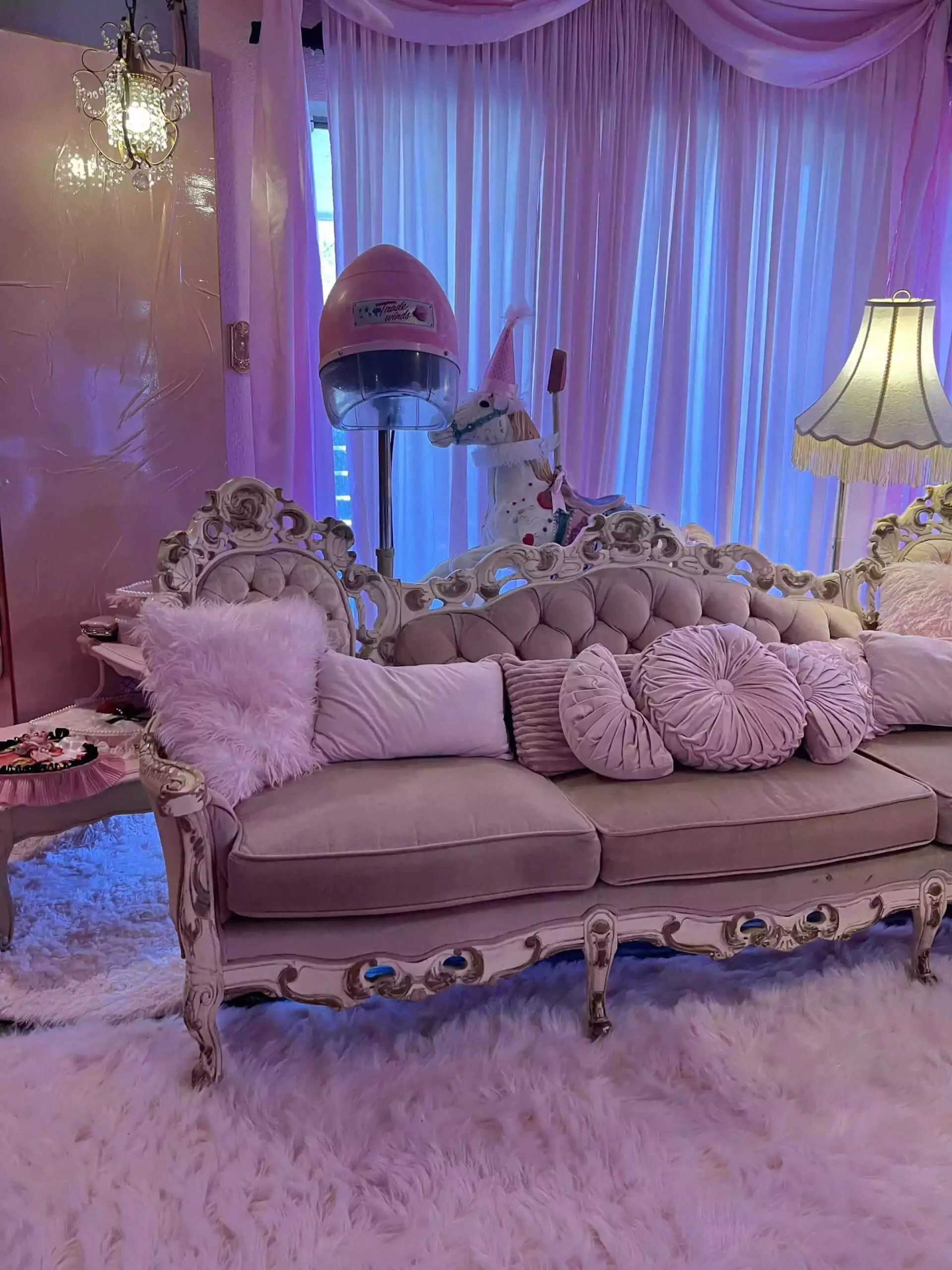 Antique pink couch covered with pillows