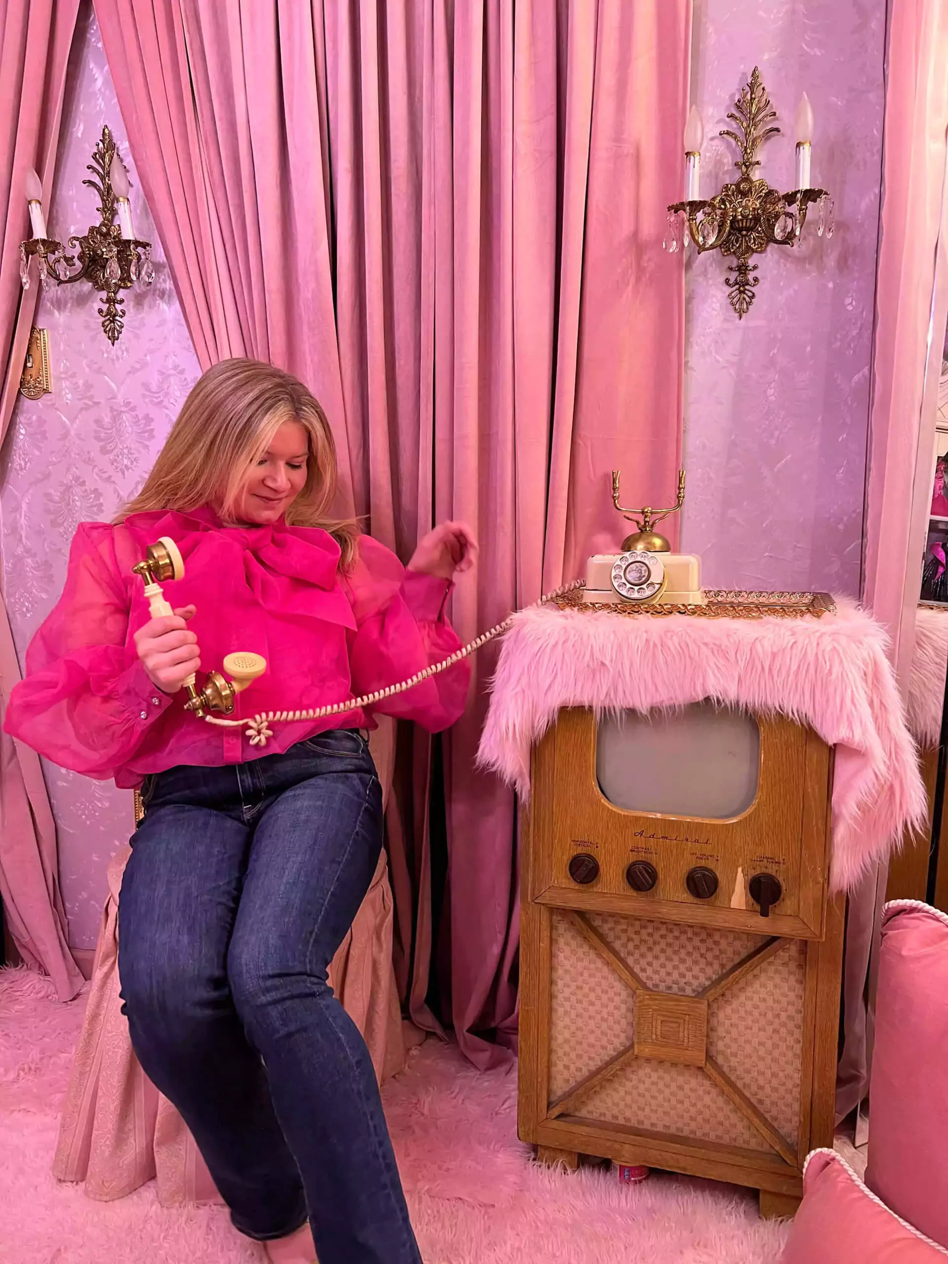 Katie sitting with antique tv and rotary phone