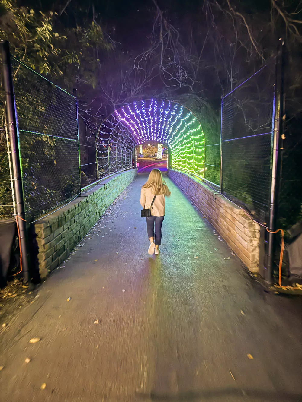 Katie walking through an arch of lights at Dallas Zoo Lights