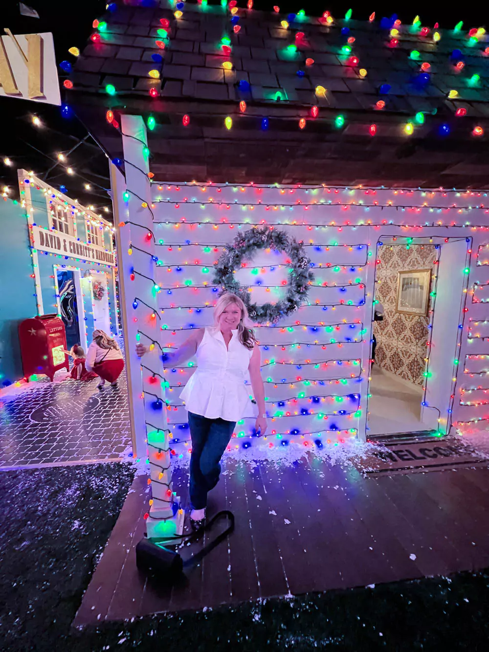Katie standing in front of Christmas lights House at SNOWDAY Pop